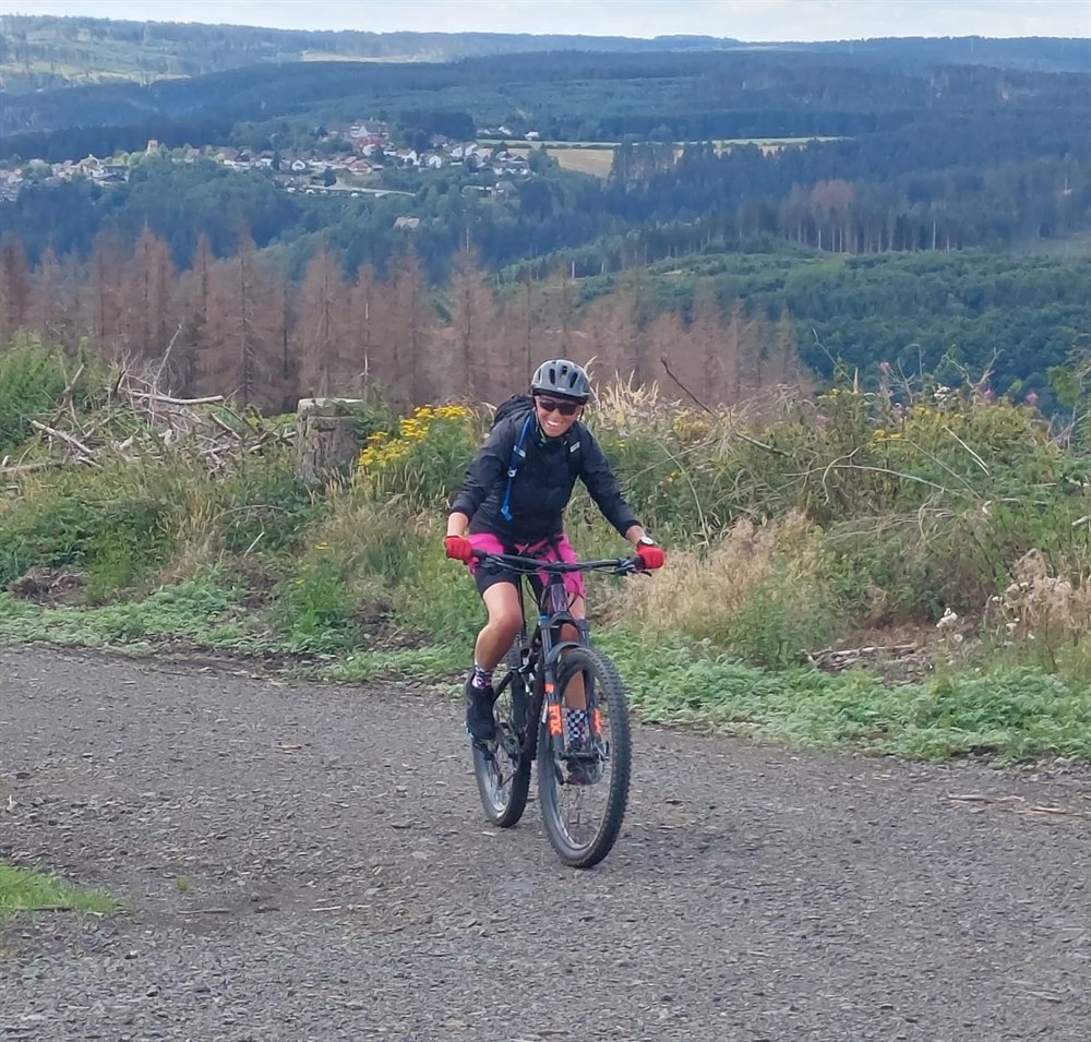 Claudia lachend auf dem Mountainbike